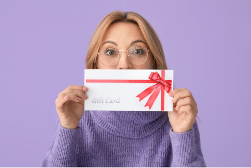 A lady holding a gift card